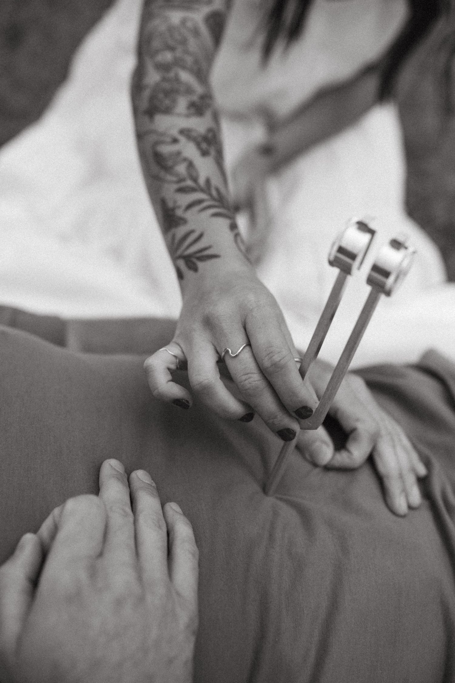 Close-up of tattooed hands making peace signs in black and white.