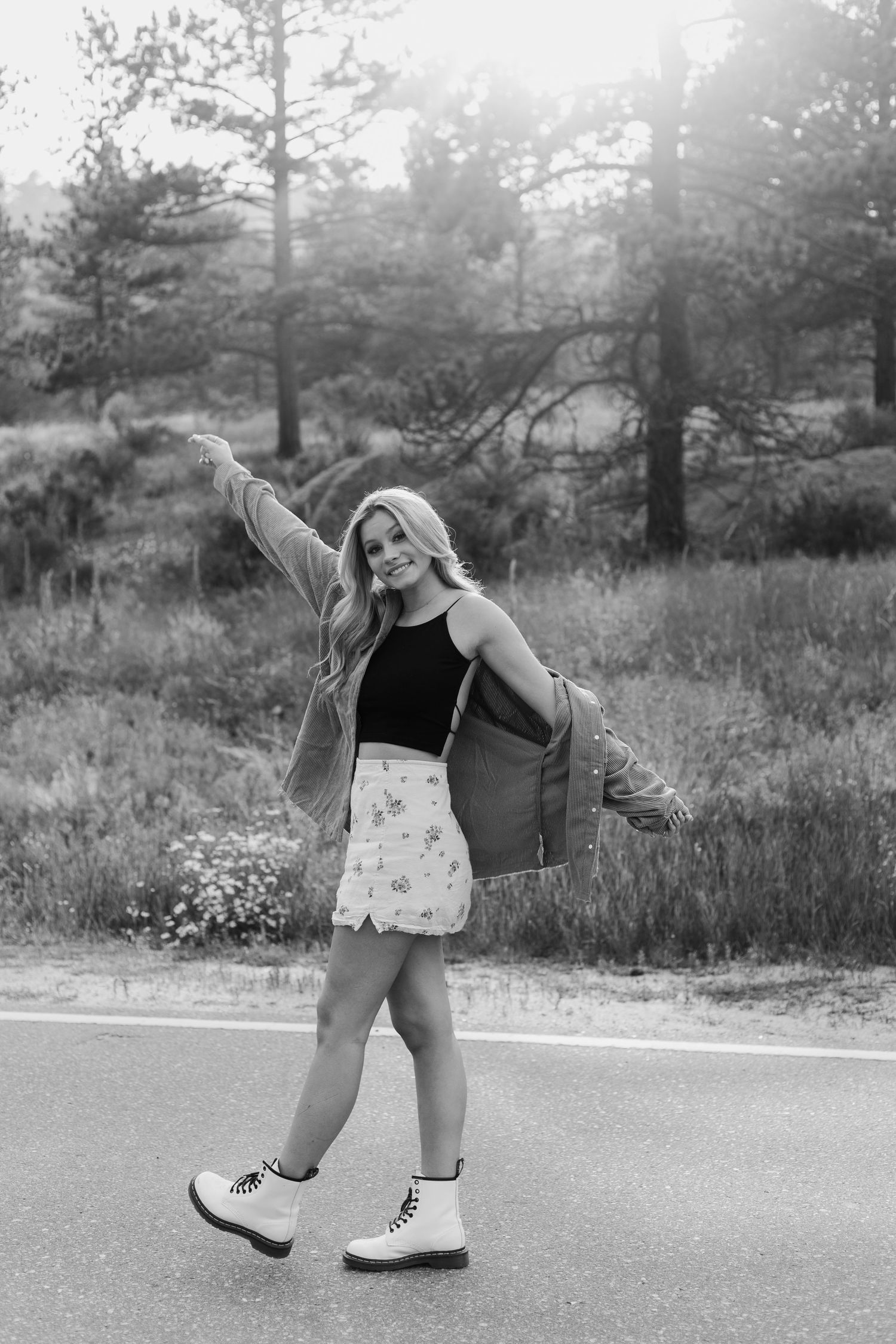 Playful black and white portraits on a paved road surrounded by pine trees.