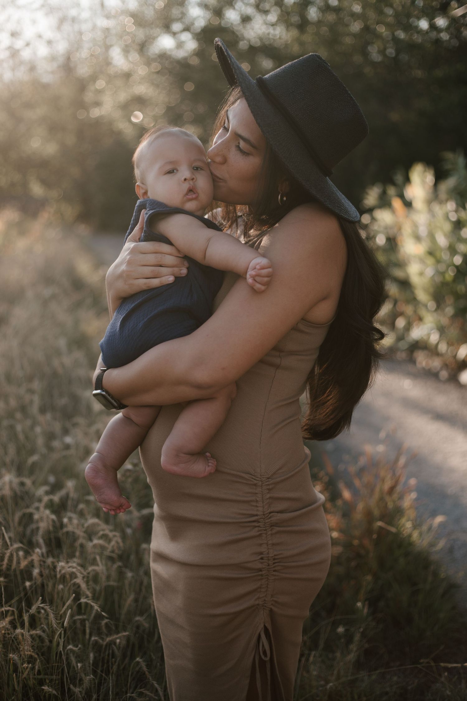 Tender moment between parent and child during golden hour outdoor photoshoot.