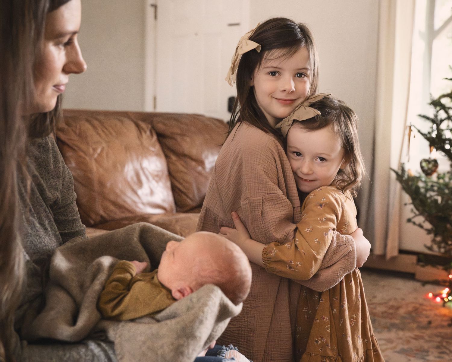 Cozy indoor family scene with siblings sharing tender moment on leather sofa.