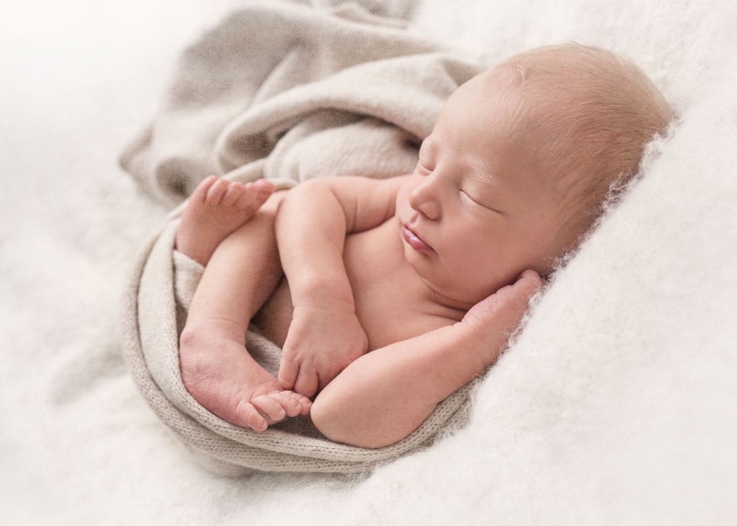 A sleeping newborn baby swaddled in white blankets shown in multiple peaceful poses during a photography session.