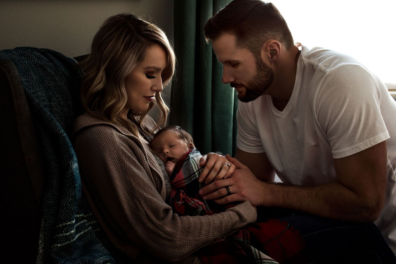 Family sharing an intimate moment together in a dimly lit room.