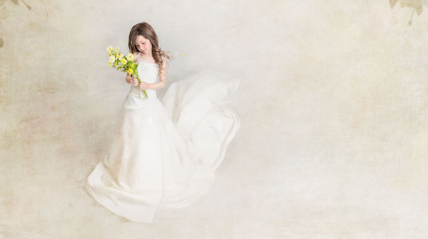 Artistic bridal portrait with white dress and yellow bouquet against light background.