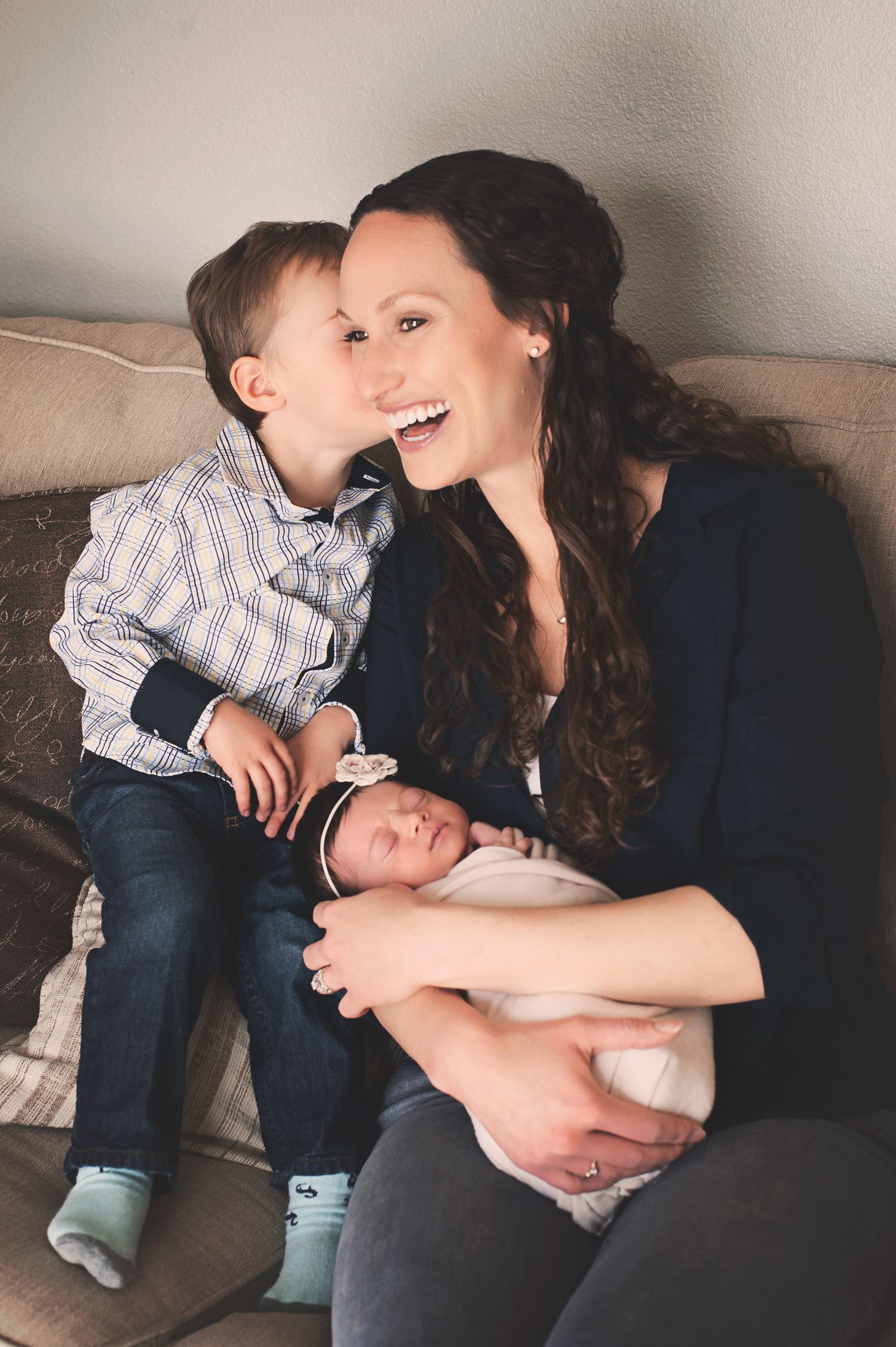 Sweet family moment with toddler sibling showing affection while newborn baby rests.