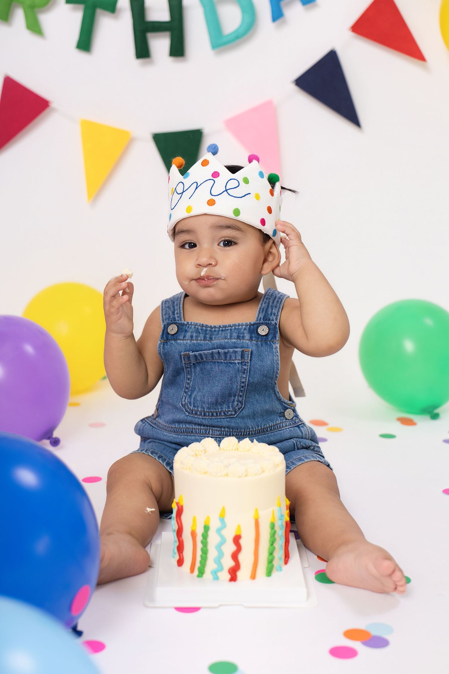 Baby in denim overalls wearing a 