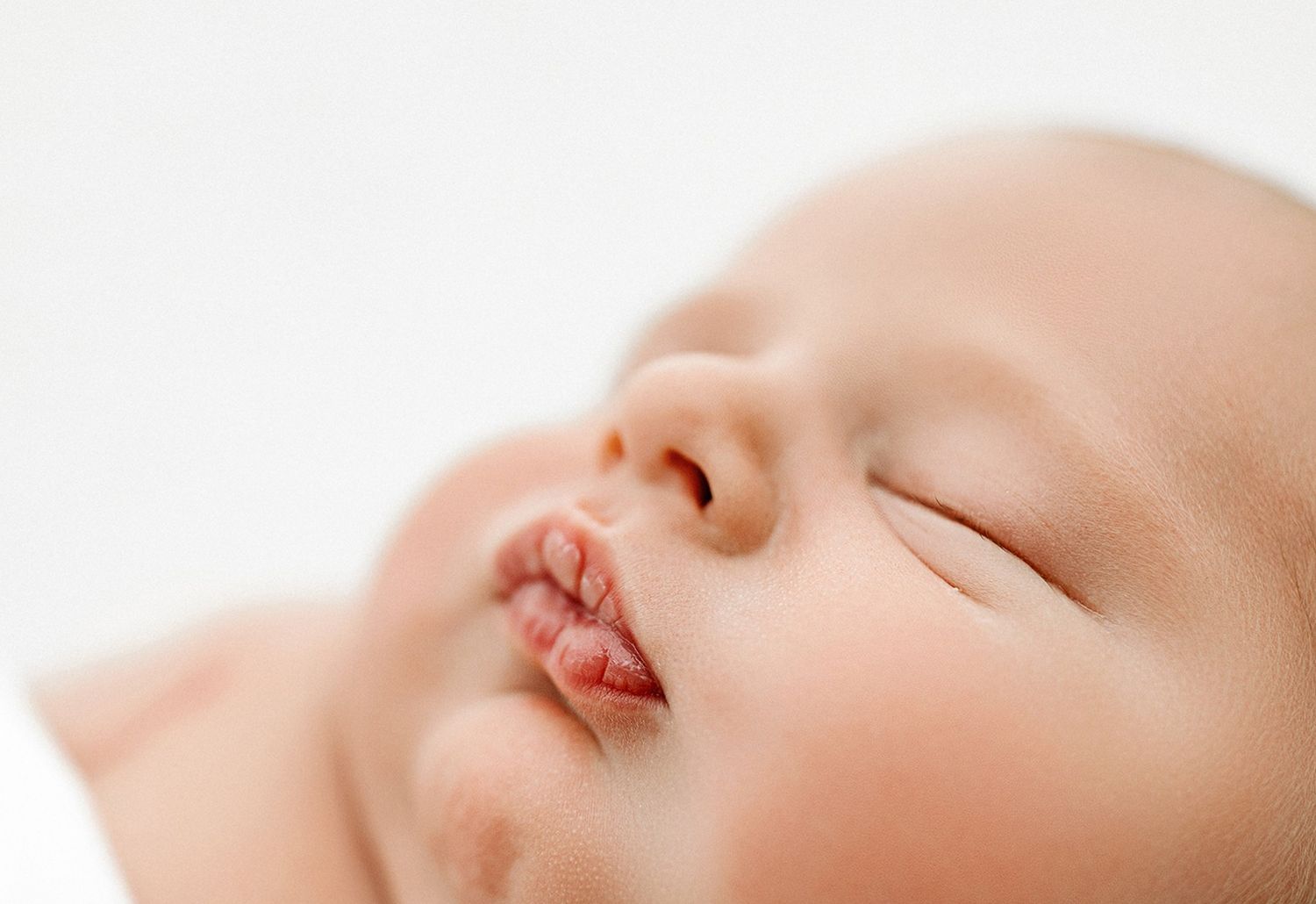 Close-up view of a baby sleeping peacefully with soft natural lighting.