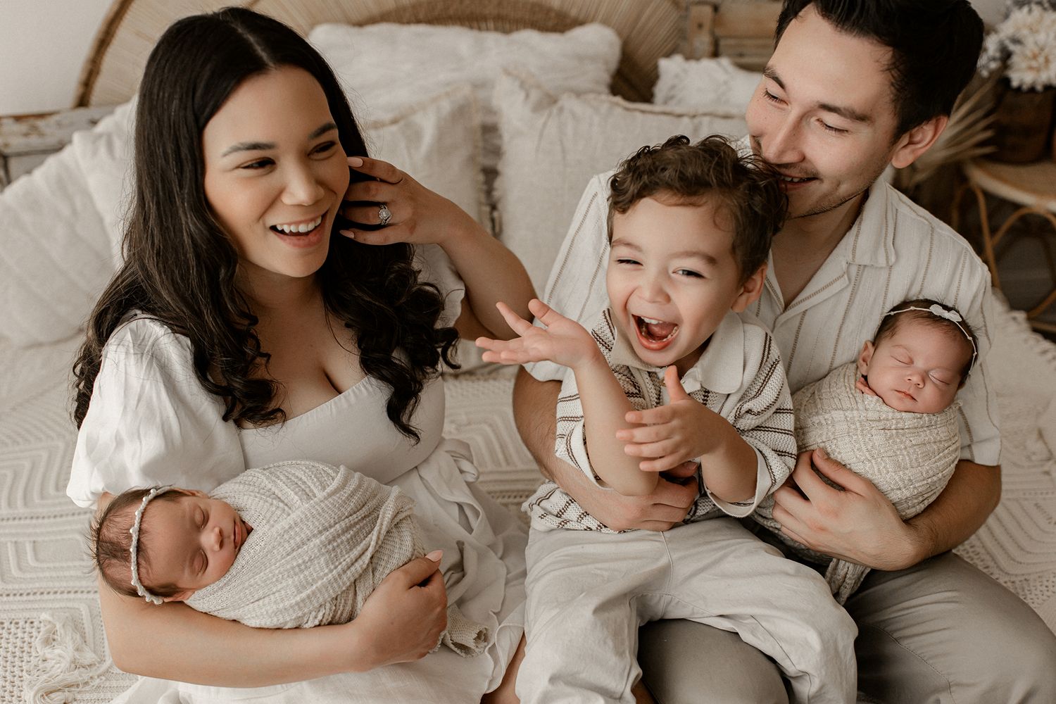 A collage of candid family photos showing intimate moments between parents and children on a white bed.