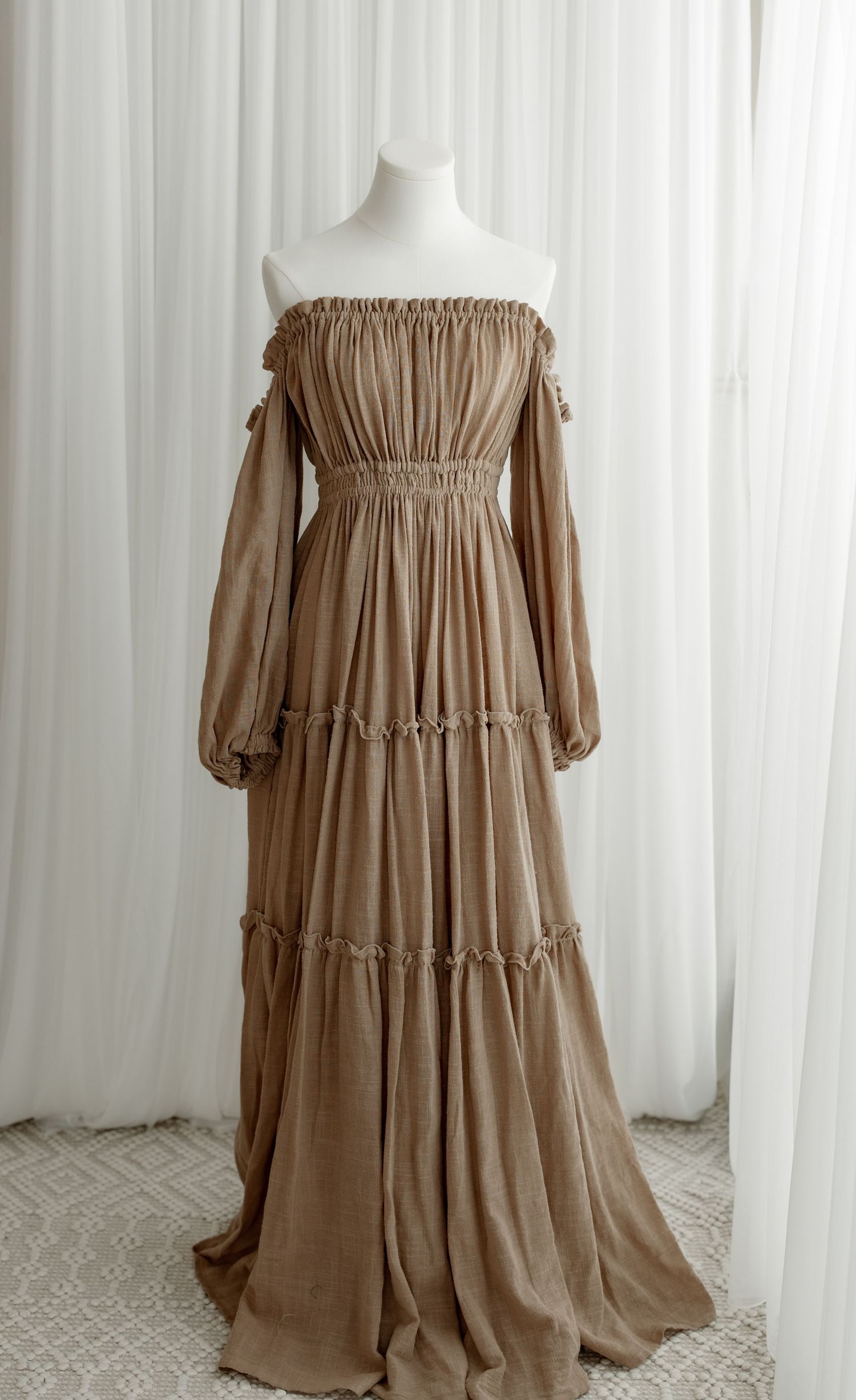 Long brown tiered maxi dress with puff sleeves and elastic waistband shown from multiple angles on white backdrop.