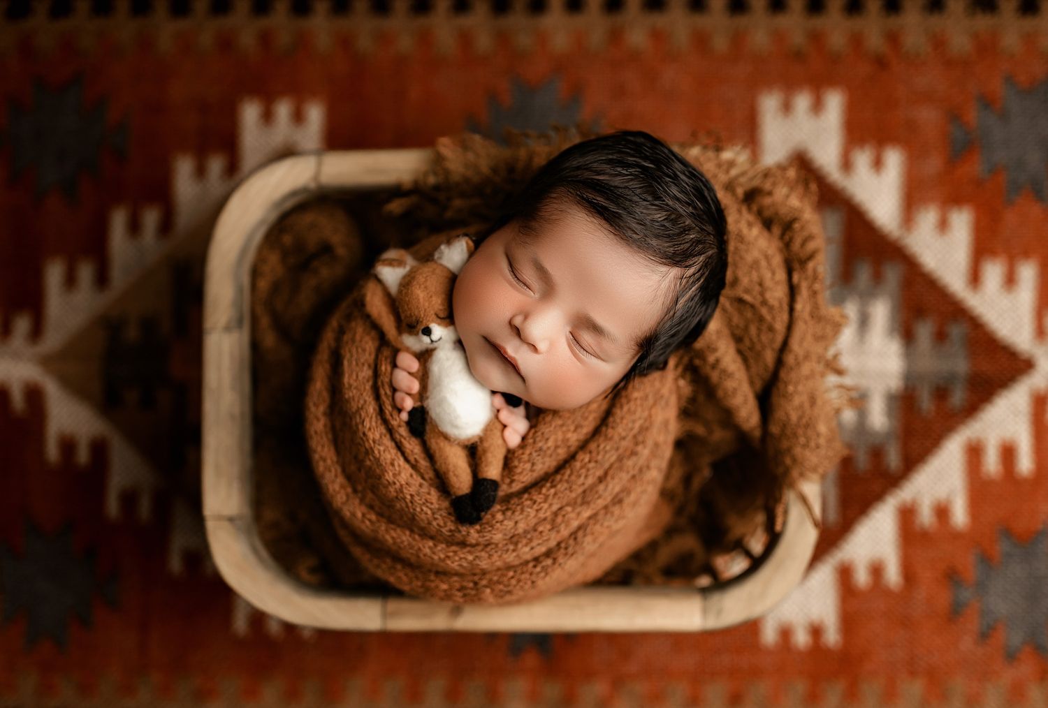 A series of newborn photos showing a sleeping baby wrapped in brown blankets with rustic southwestern decor.