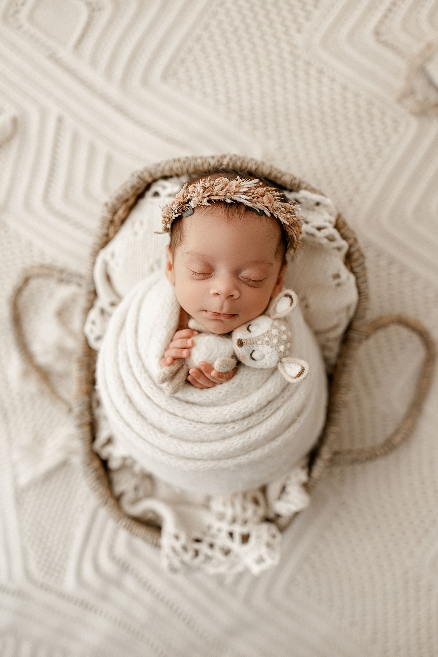 A series of five newborn photography shots showing a sleeping baby wrapped in cream-colored blankets with soft textures.