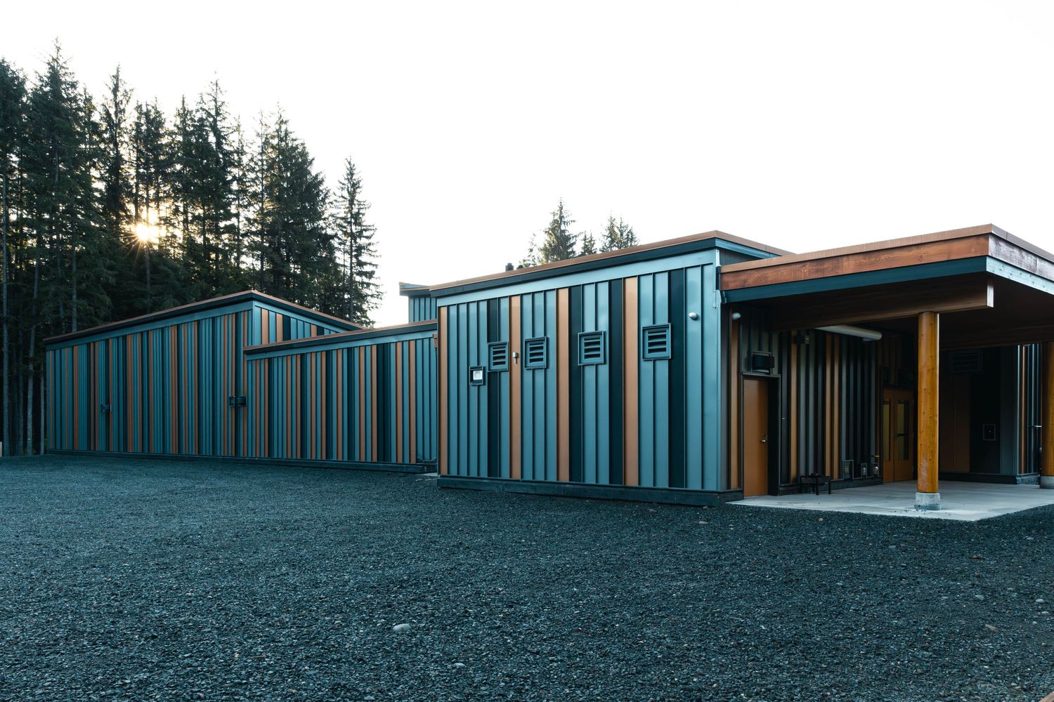 Long commercial building with alternating wood and blue vertical siding panels.