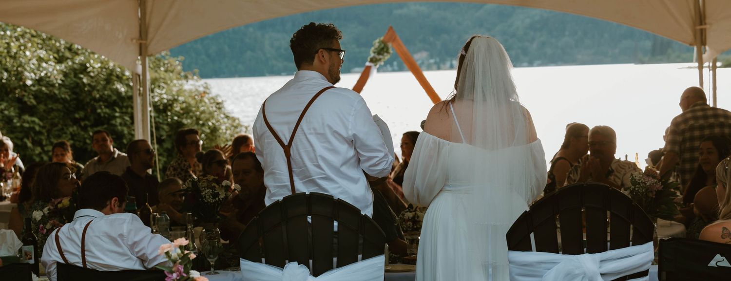 Couple dancing together under a covered outdoor venue during their wedding reception.