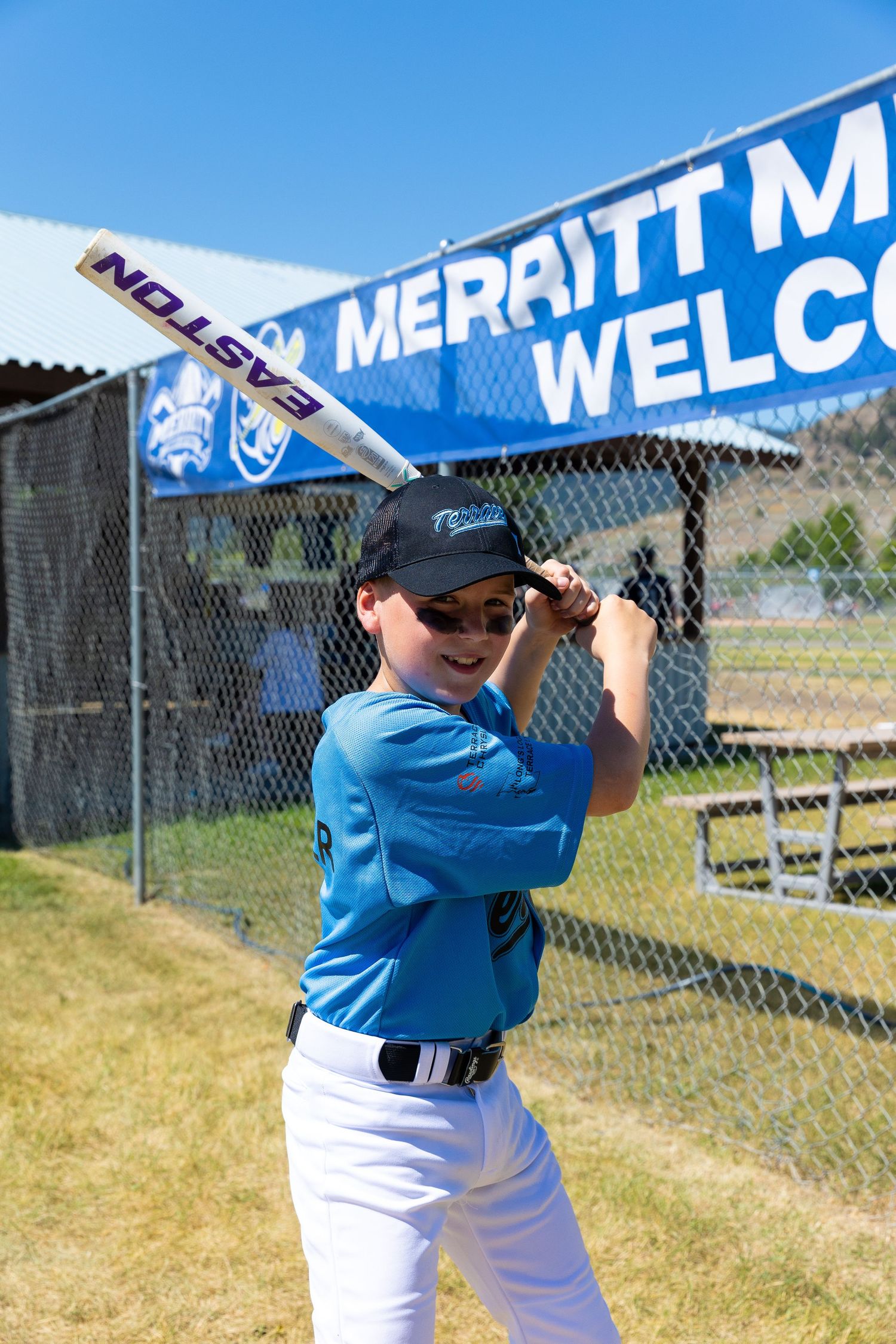 Young baseball player practicing batting stance at field.