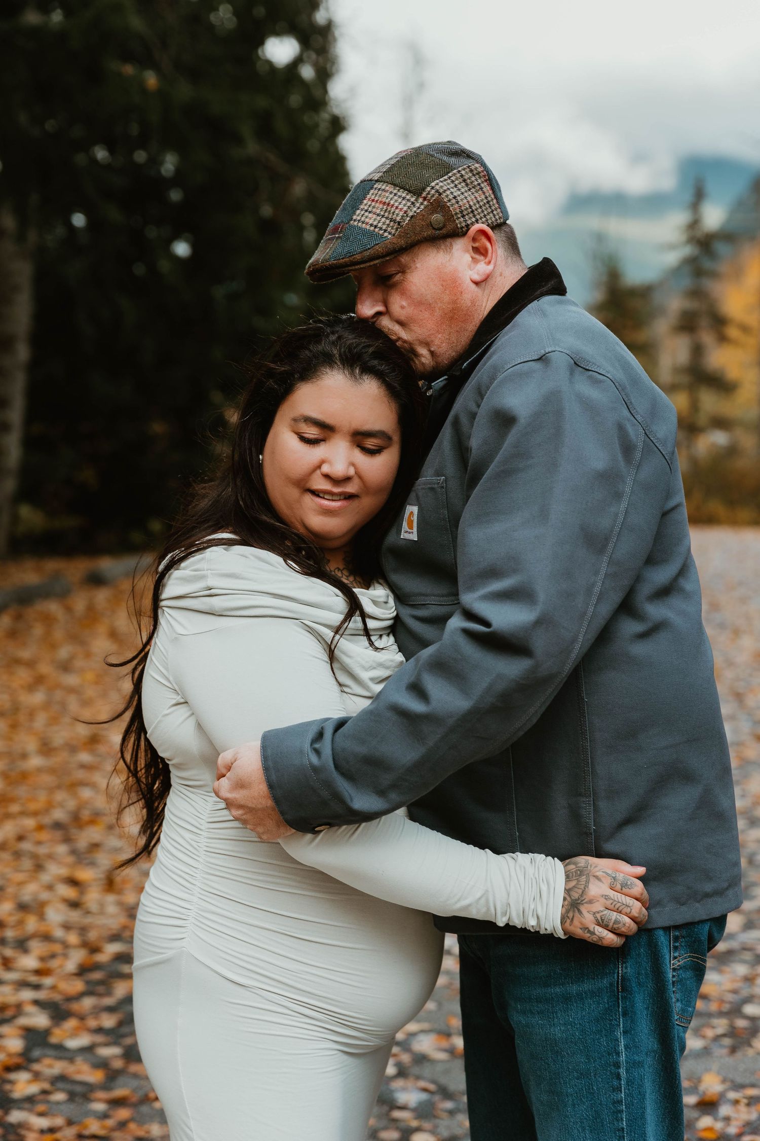 An intimate autumn portrait session among fallen leaves and evergreen trees.