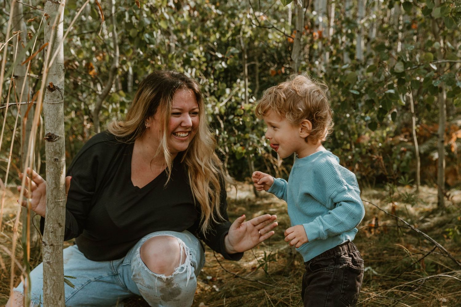 Candid outdoor photo showing playful interaction in woodland setting.