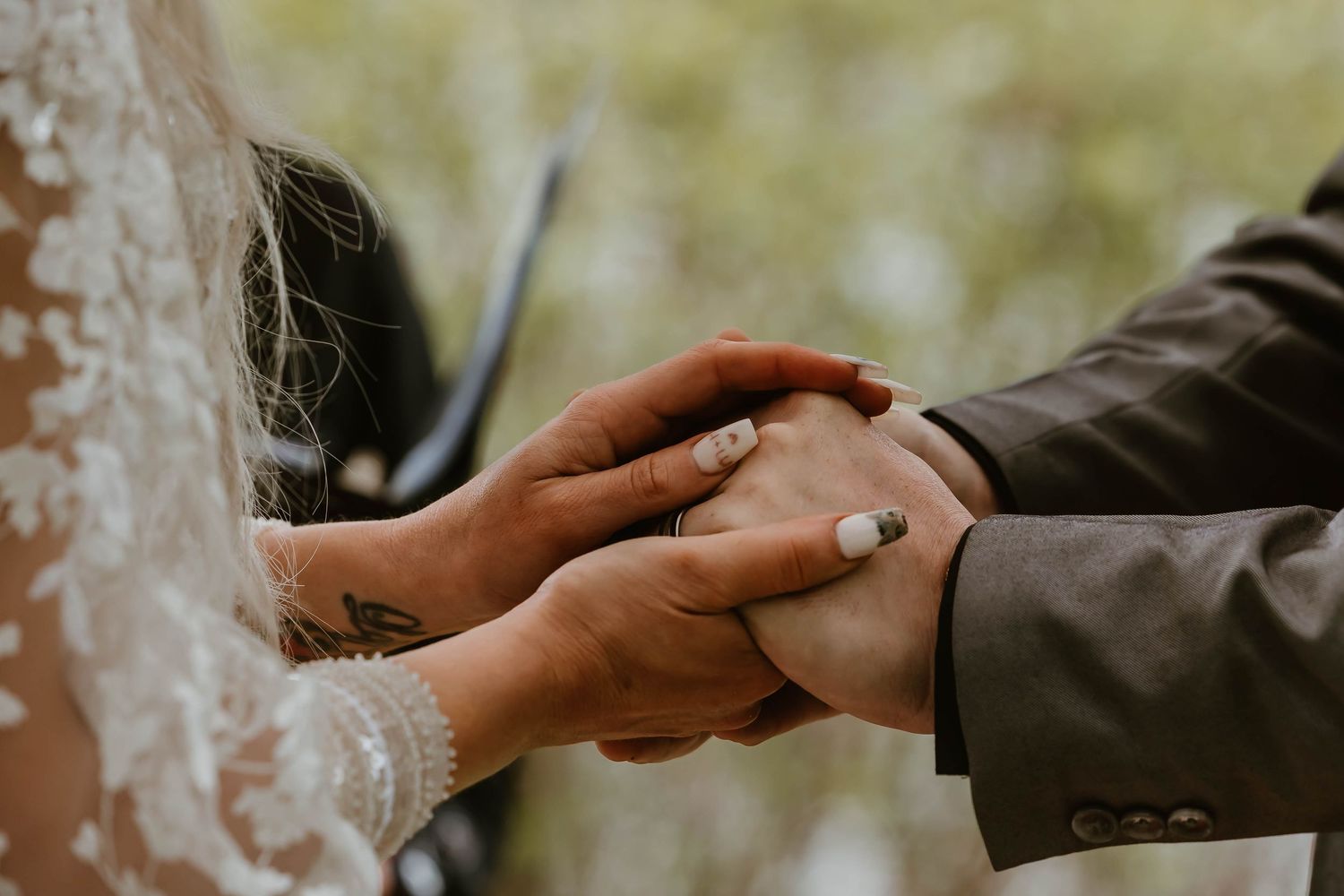 Close-up photos of hands exchanging rings during an intimate outdoor wedding ceremony in natural light.