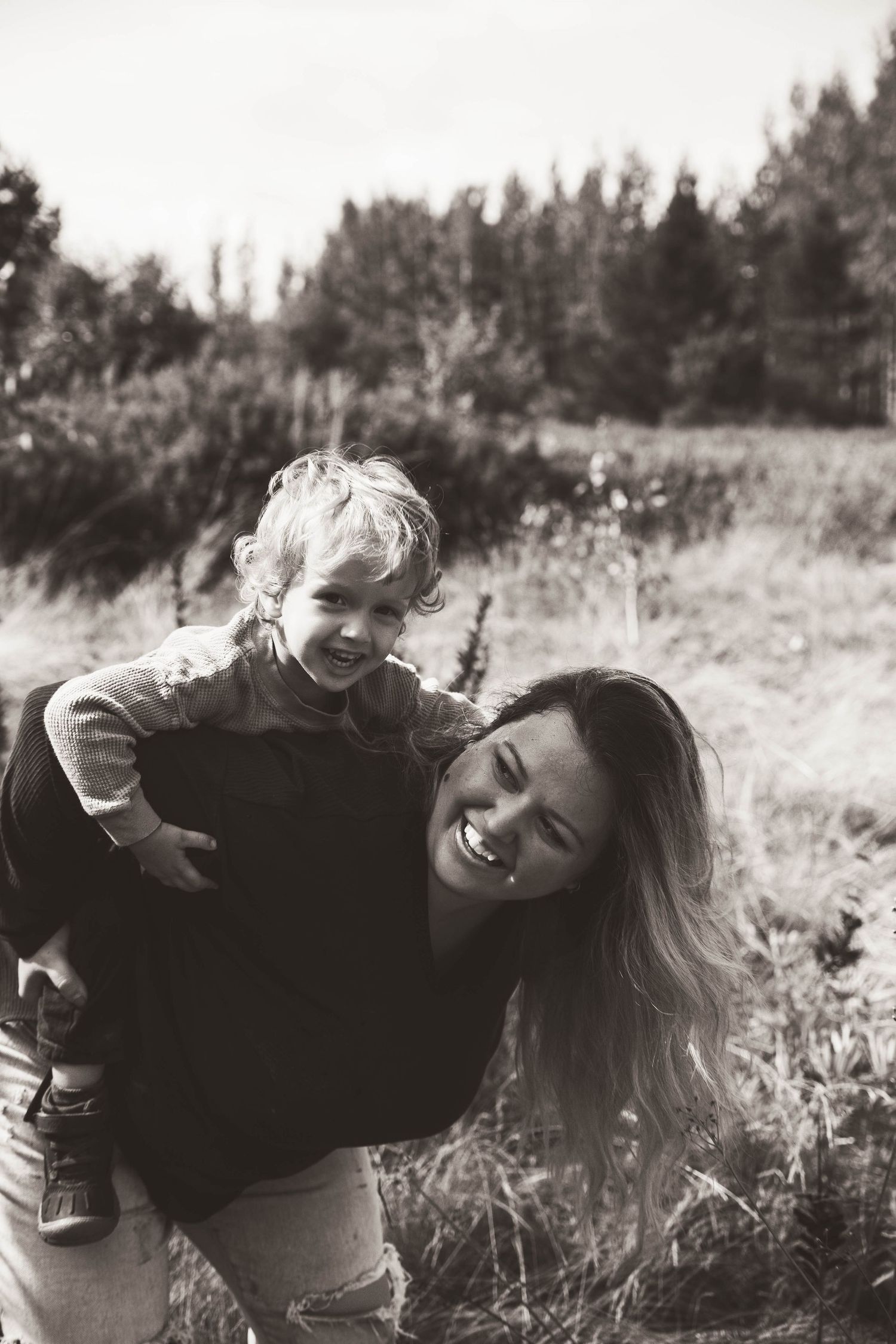 Black and white candid photo capturing joyful moment outdoors in nature.