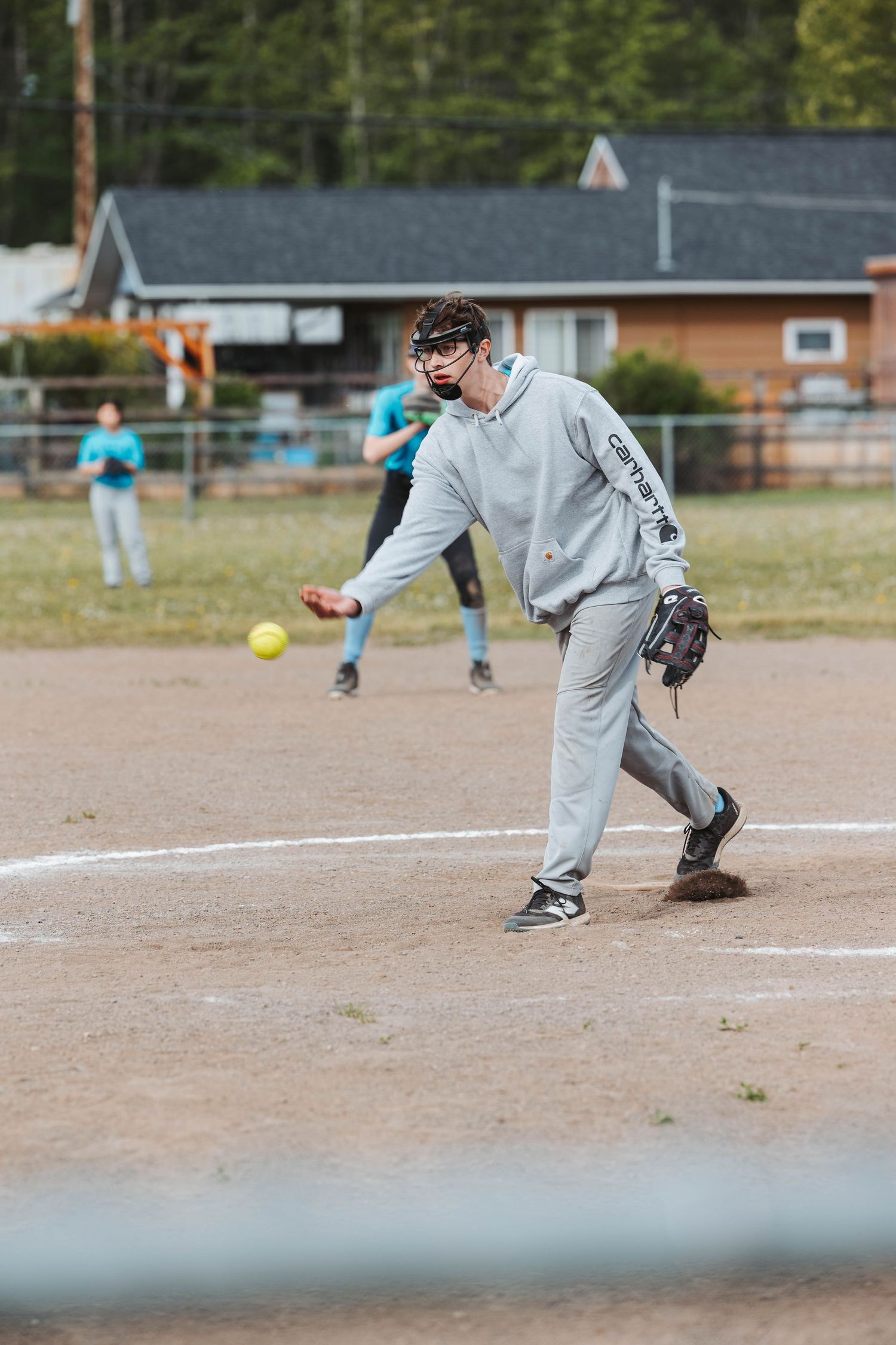 Pitcher in gray uniform delivers pitch during baseball game.