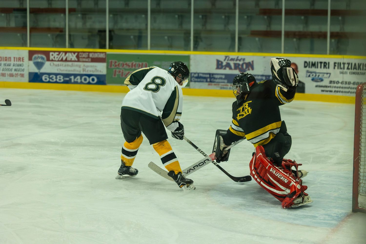 Hockey players battle for the puck near the goal during an ice hockey match.