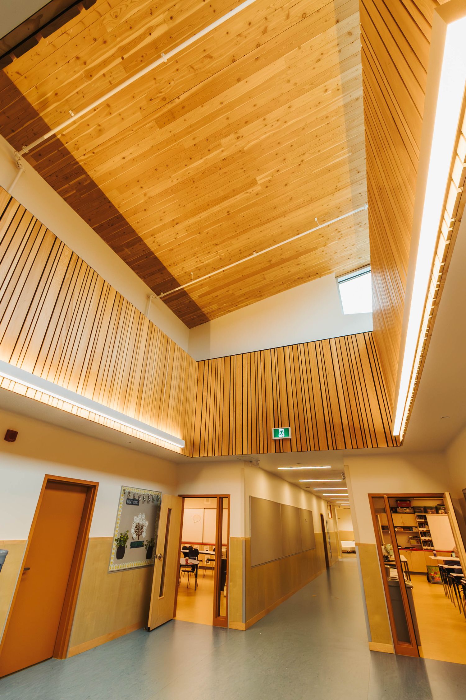 Modern interior hallway with wooden ceiling panels and warm lighting design.
