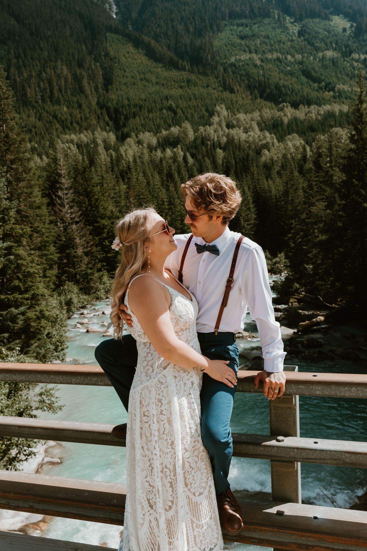 A tender moment shared on a bridge overlooking a mountain lake.