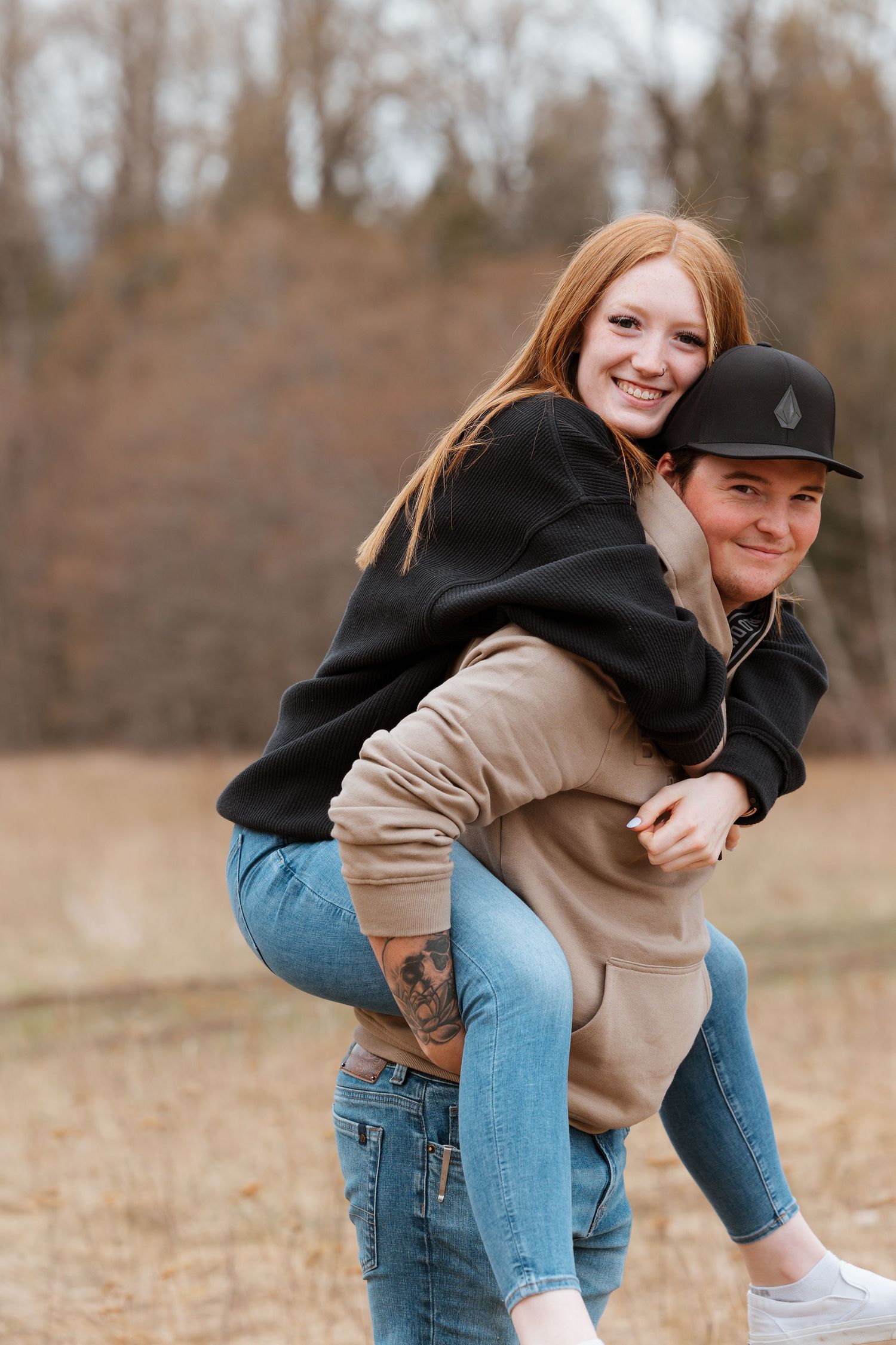 Playful piggyback ride moment captured in autumn field setting.