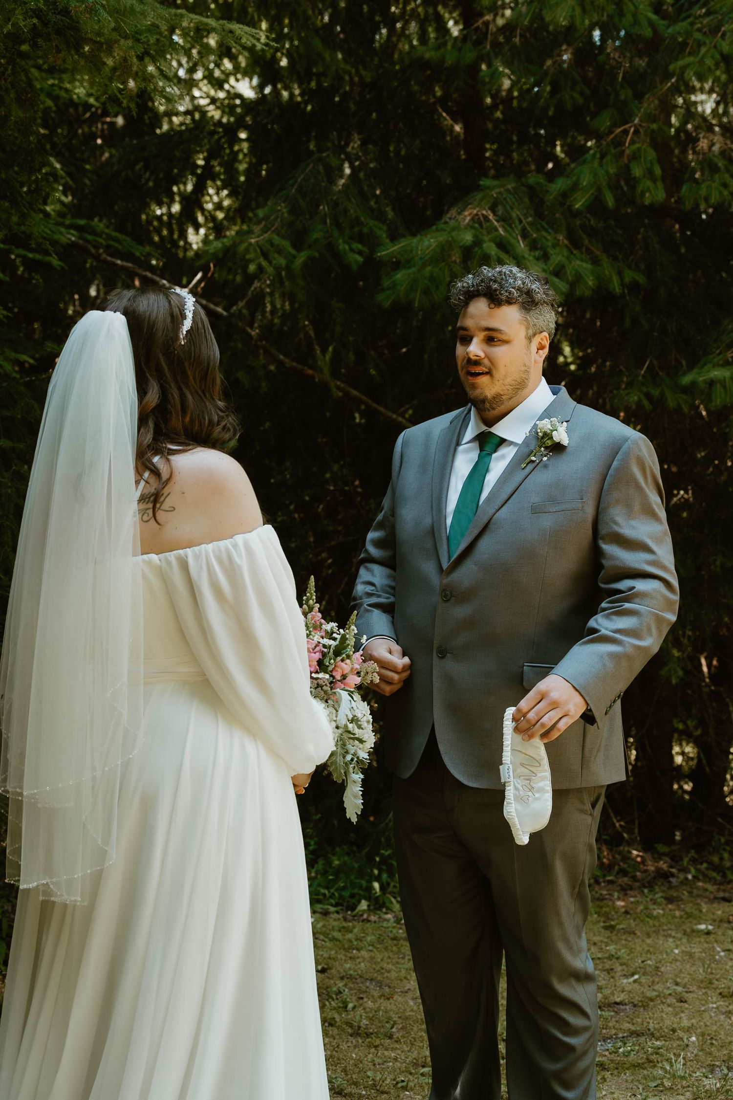 Couple exchanges vows in intimate forest wedding setting.