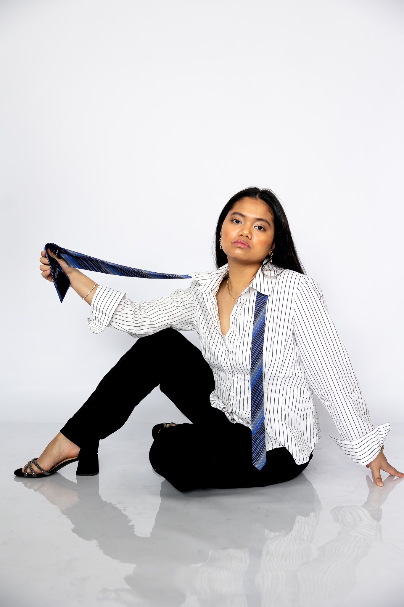 Professional wearing a striped button-down shirt and tie poses on white floor in four dynamic reclining positions.