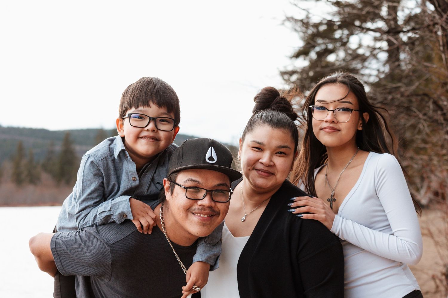 Family group poses together outdoors in a casual portrait with natural background.
