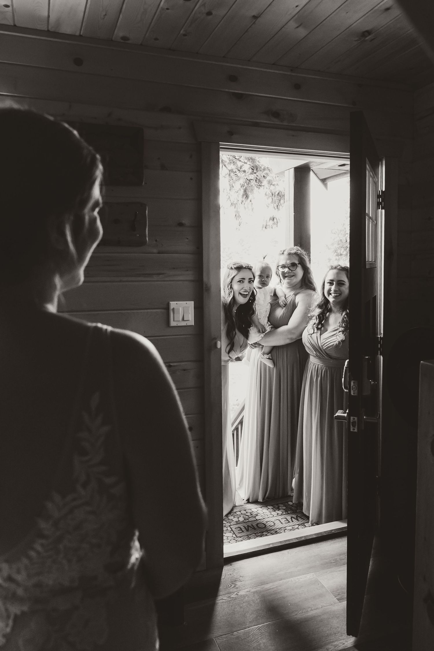 A series of black and white photos showing a wedding party getting ready in a rustic cabin interior.