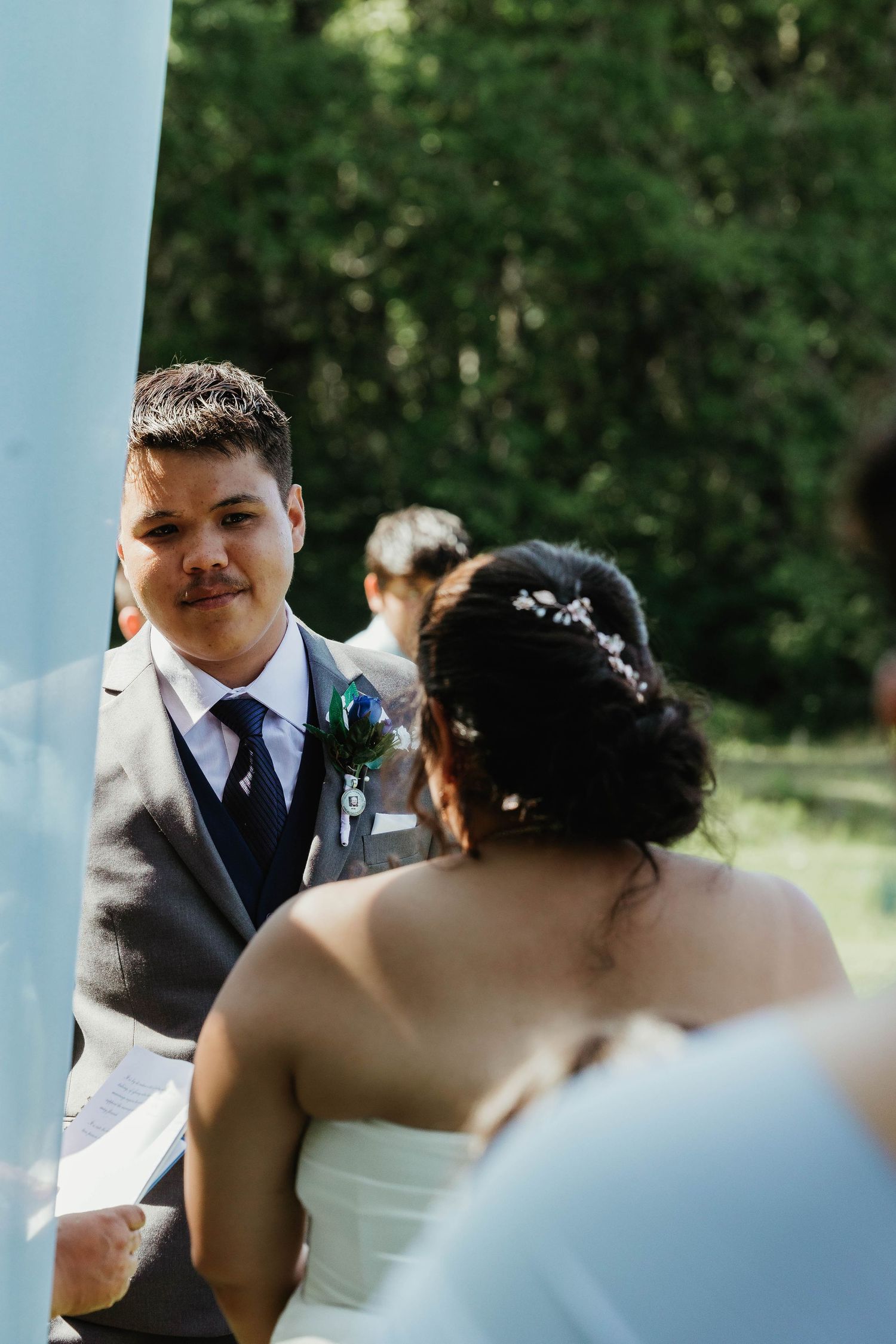 Close-up of a tender moment during an outdoor wedding ceremony.