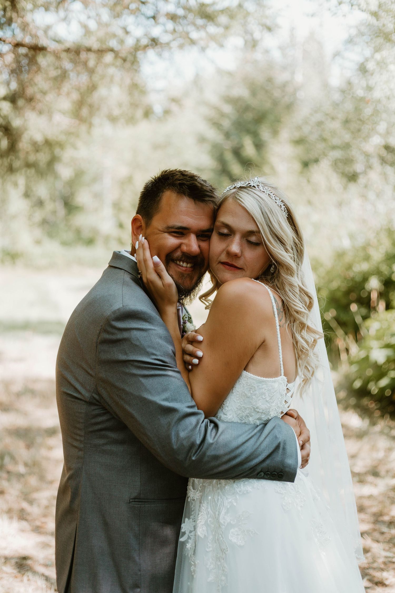 A romantic wedding portrait showing tender moments between a couple in an outdoor setting.