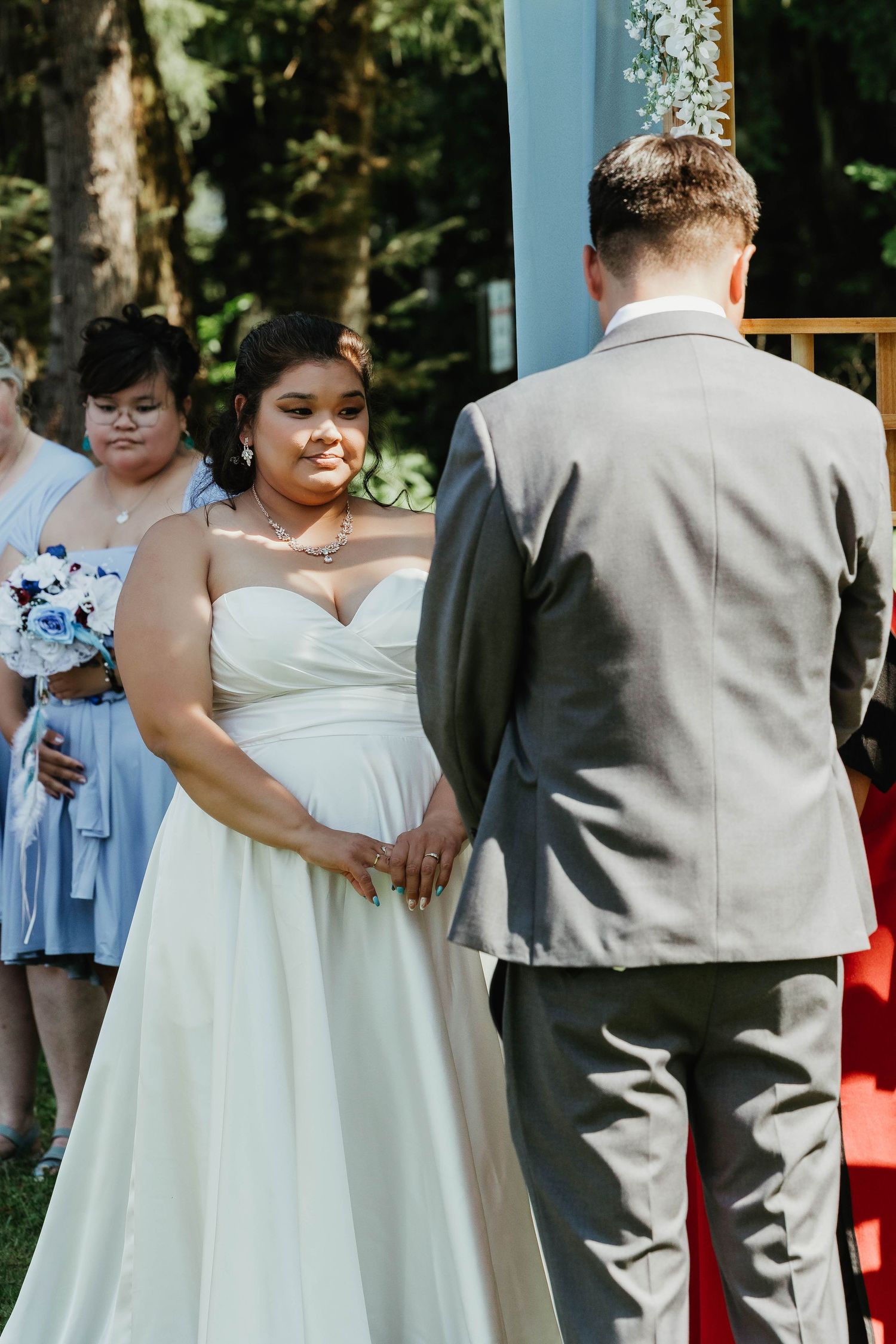 Intimate moment during an outdoor wedding ceremony surrounded by greenery.