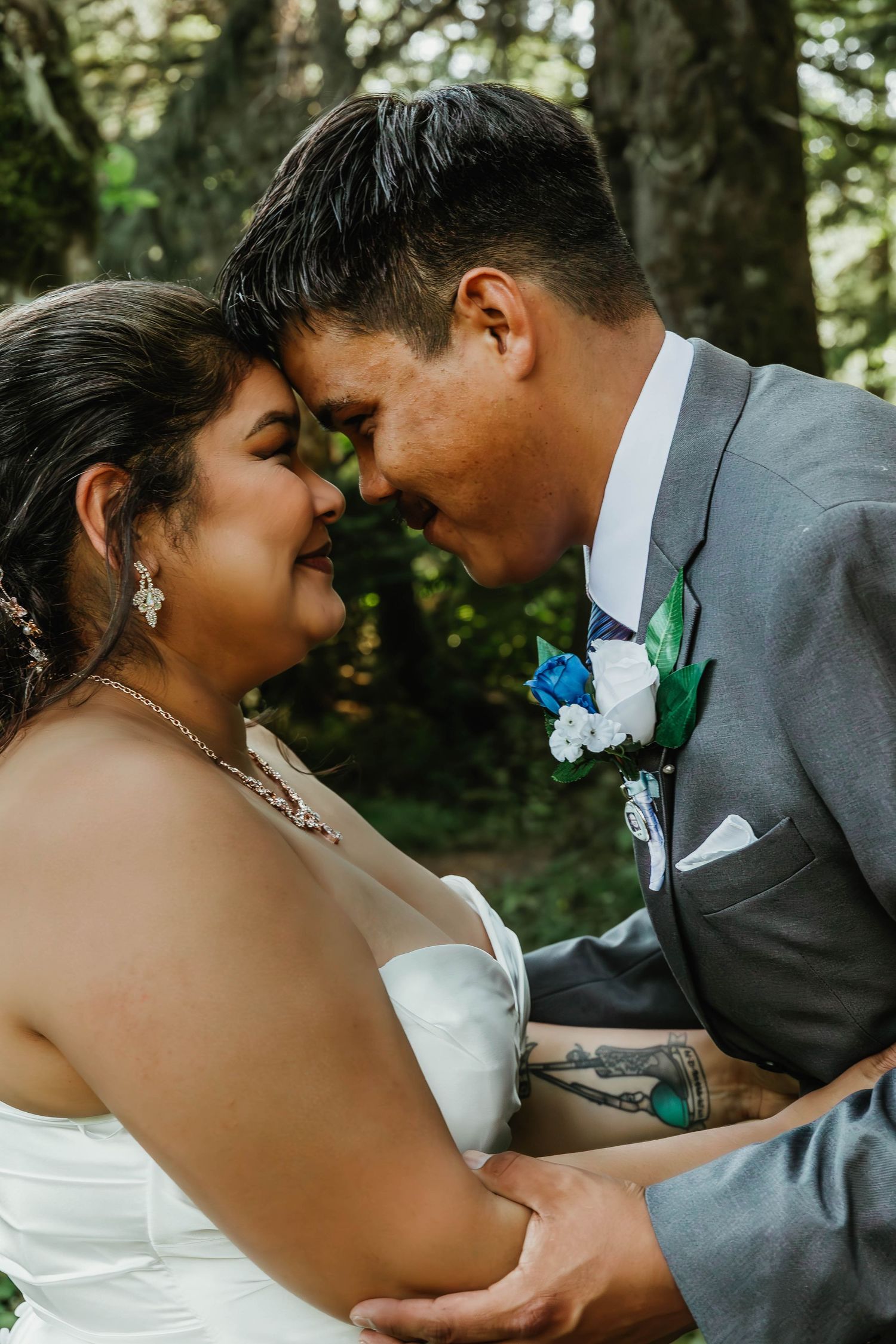 Intimate romantic moment between newlyweds in a forest setting.