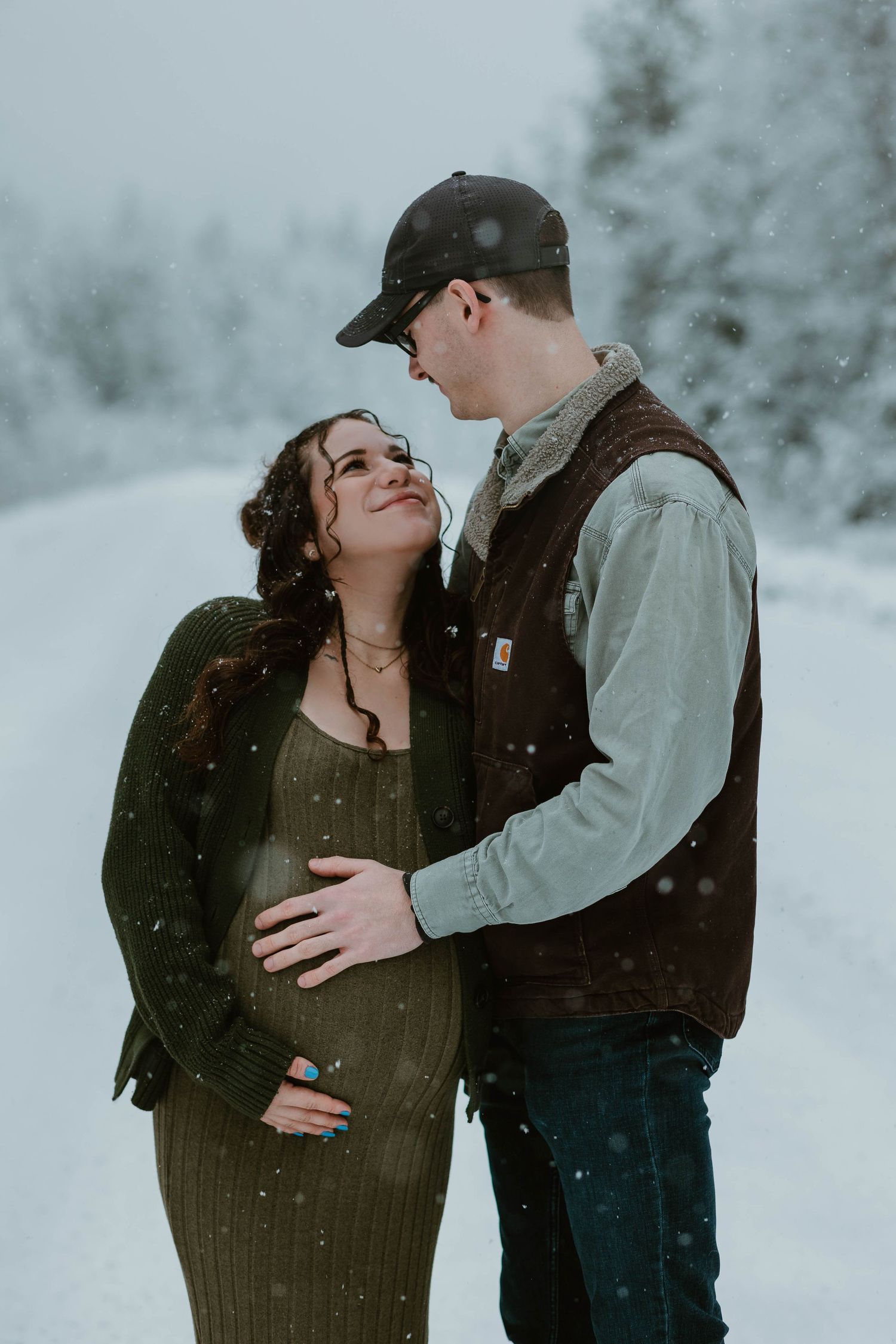 A tender winter moment between a couple sharing an intimate embrace in the snow.