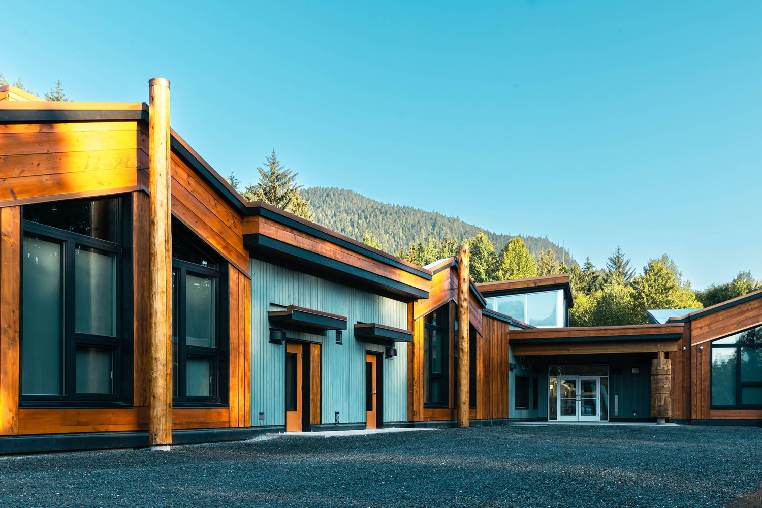 Contemporary wood and glass commercial building with mountain views in background.