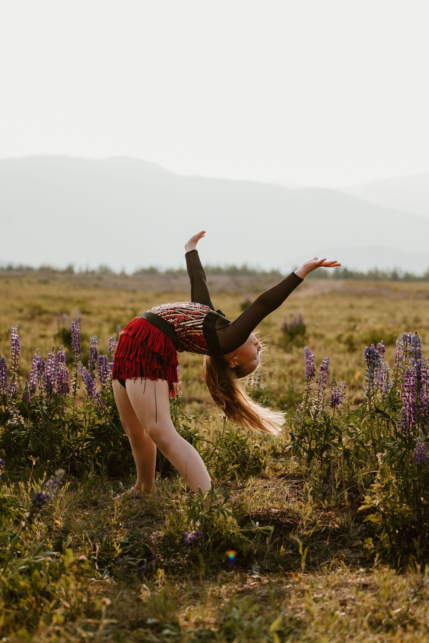 Sequential photos show a person levitating above a lupine field at sunset with a flowing red dress and dramatic pose.