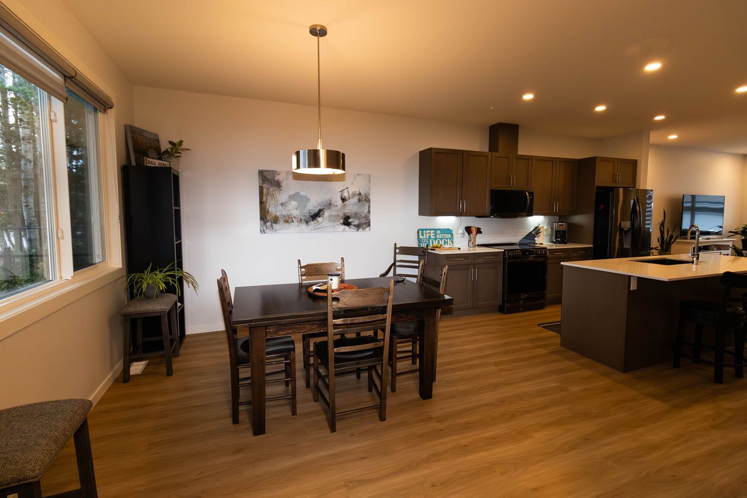 Open concept kitchen and dining area with hardwood floors and dark wood cabinetry.