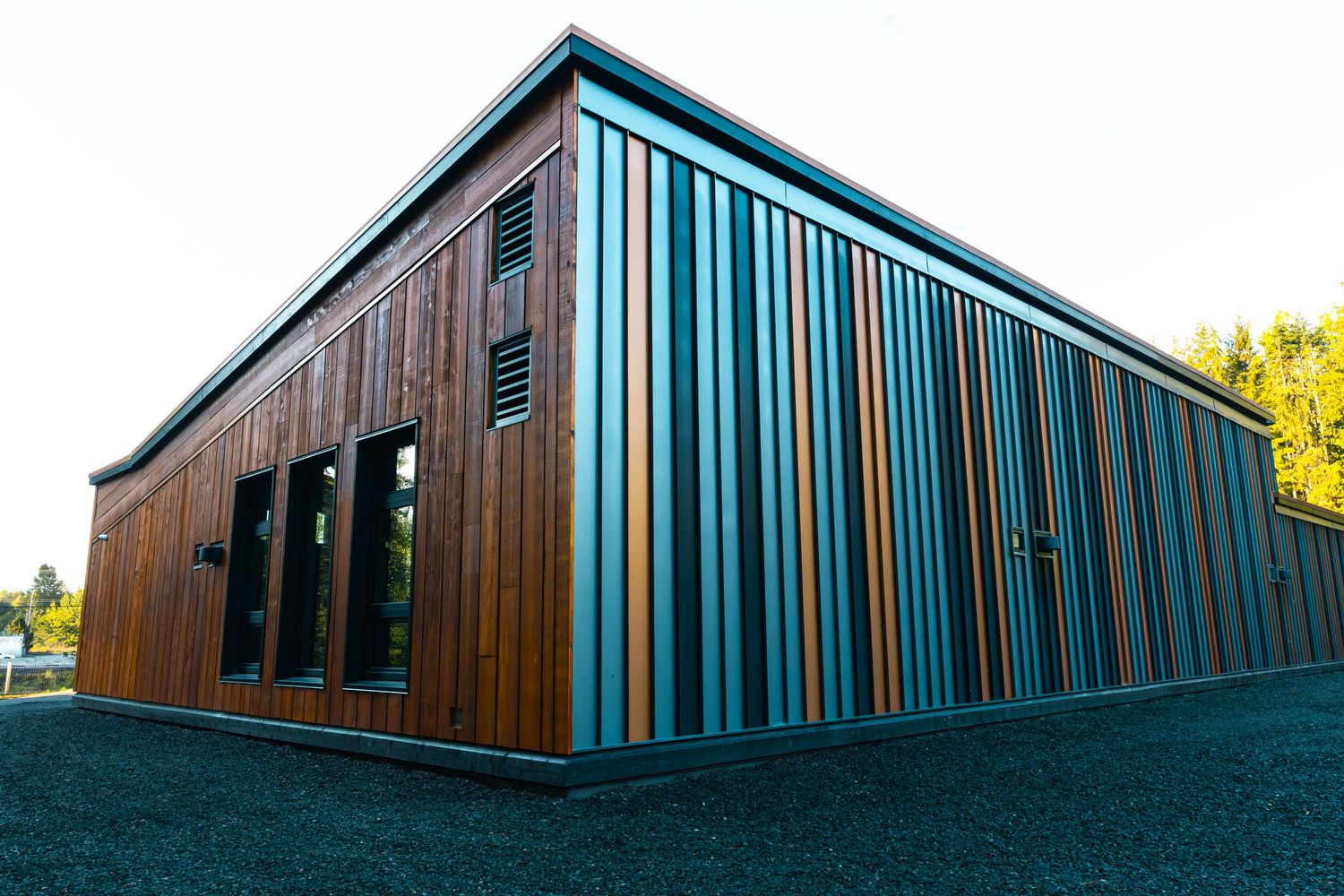 Modern commercial building exterior with vertical wood and teal striped siding design.