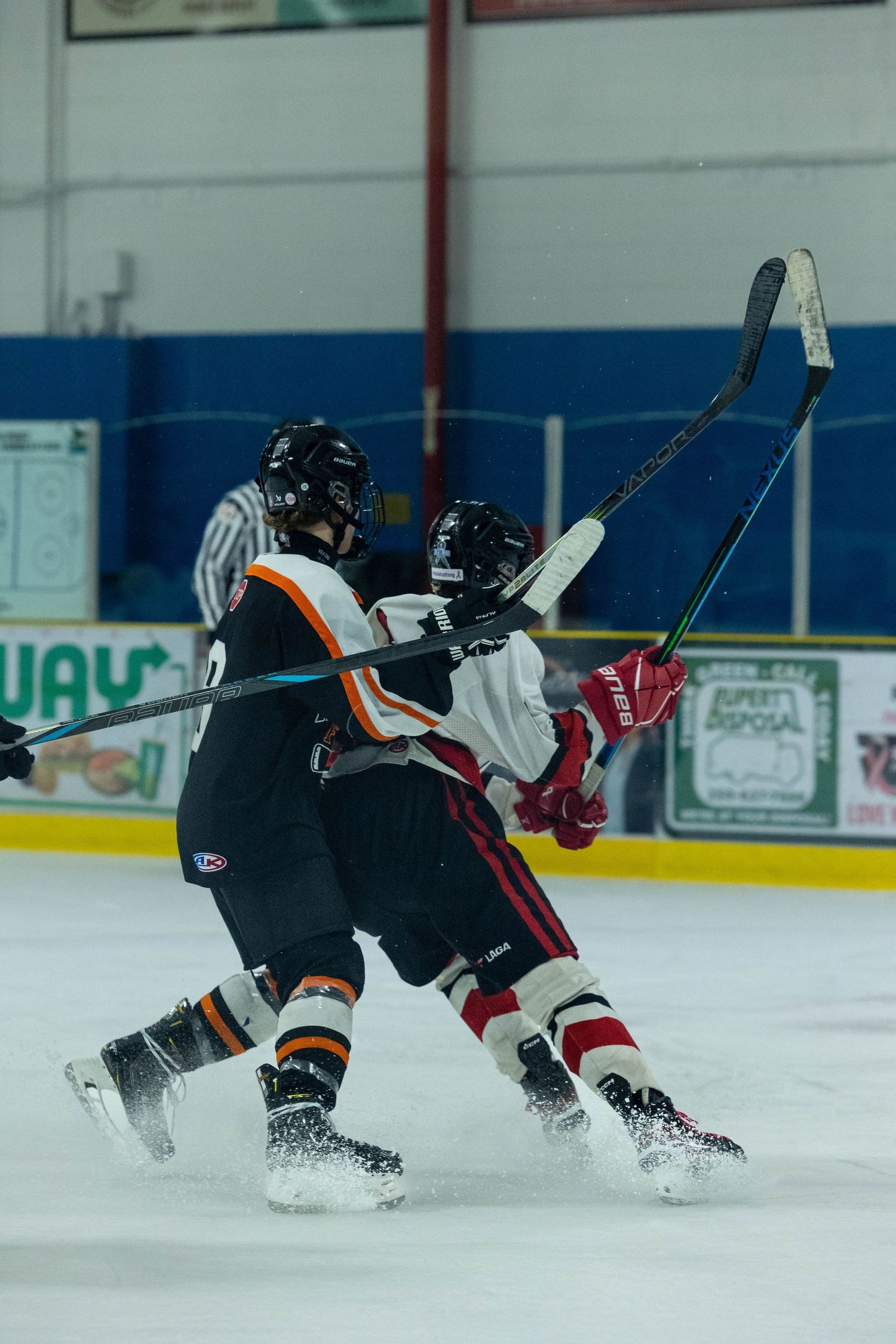Two hockey players collide in a physical battle along the boards during a game.