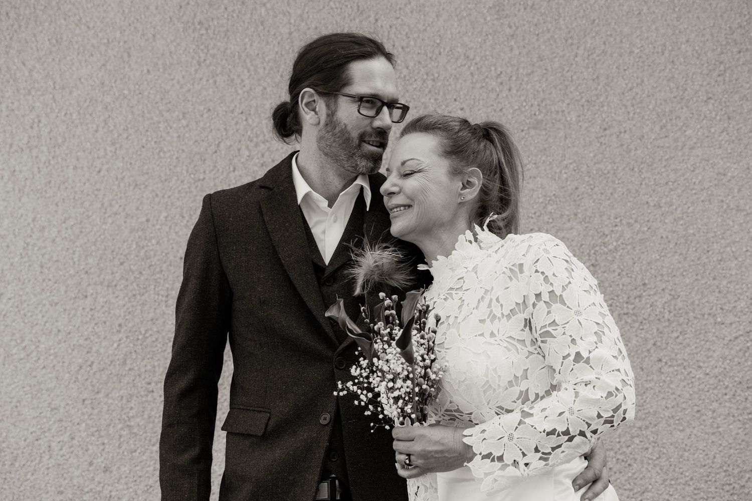 A black and white portrait of newlyweds sharing an intimate moment.