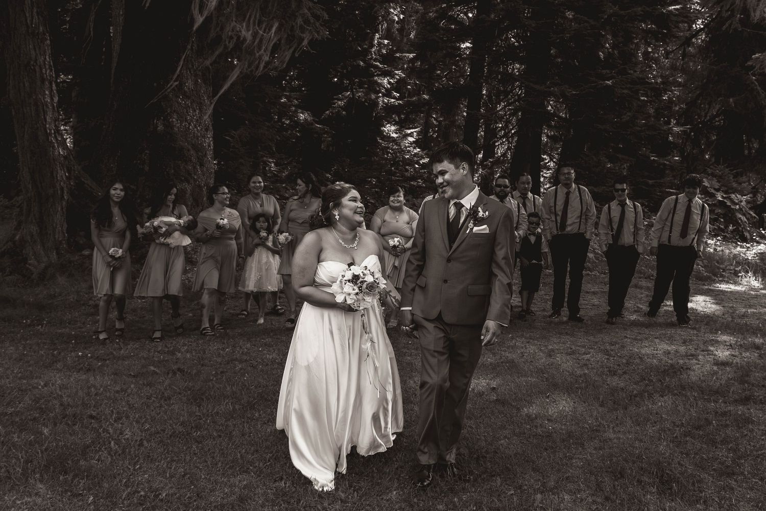 Wedding party standing in a forest setting with a black and white vintage effect.
