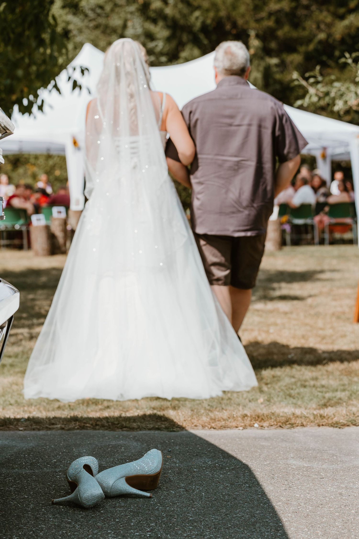 Wedding dress flows elegantly as pair walks across outdoor venue grounds.