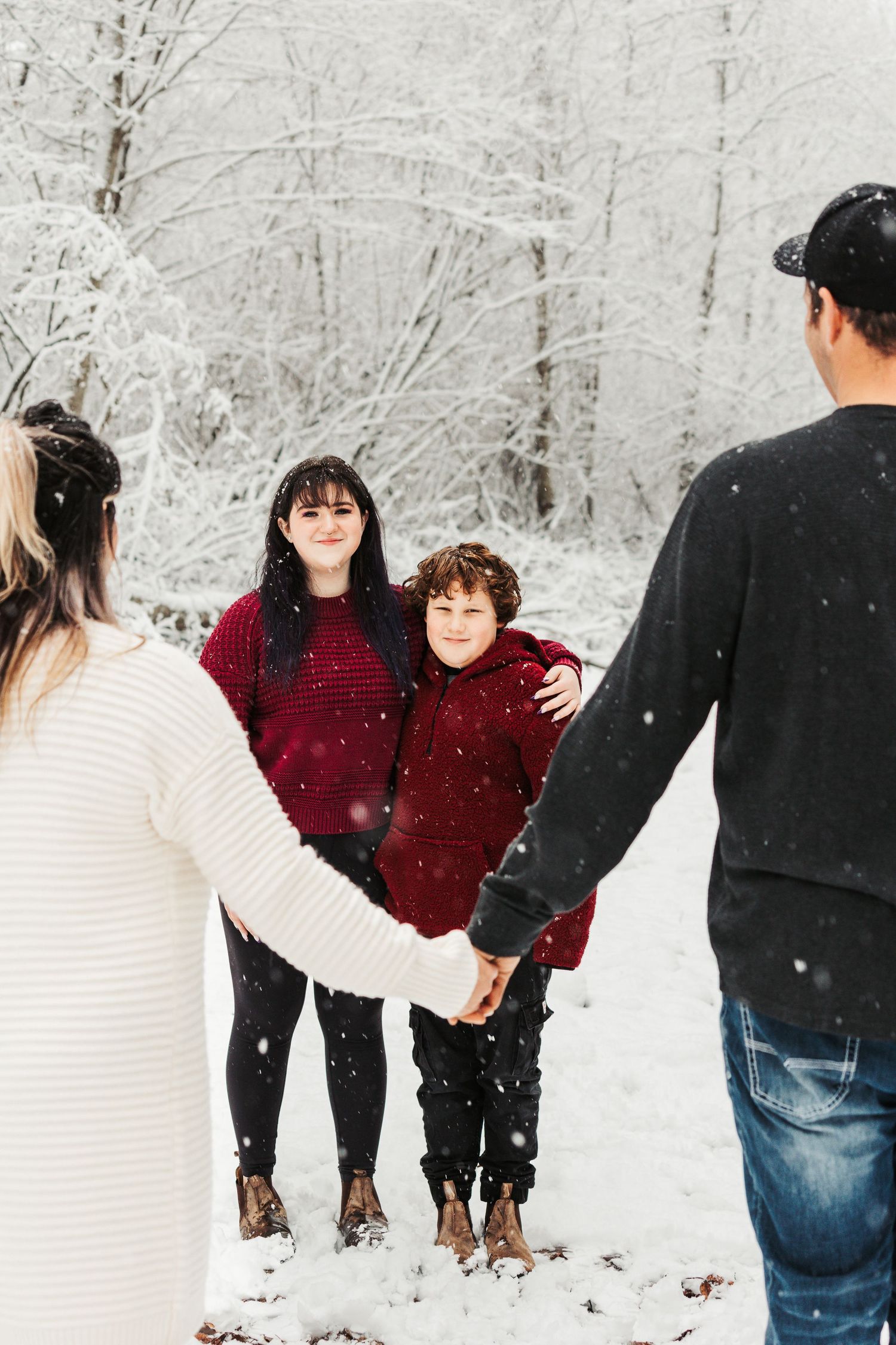 A snowy winter scene with people posing together among snow-covered trees.