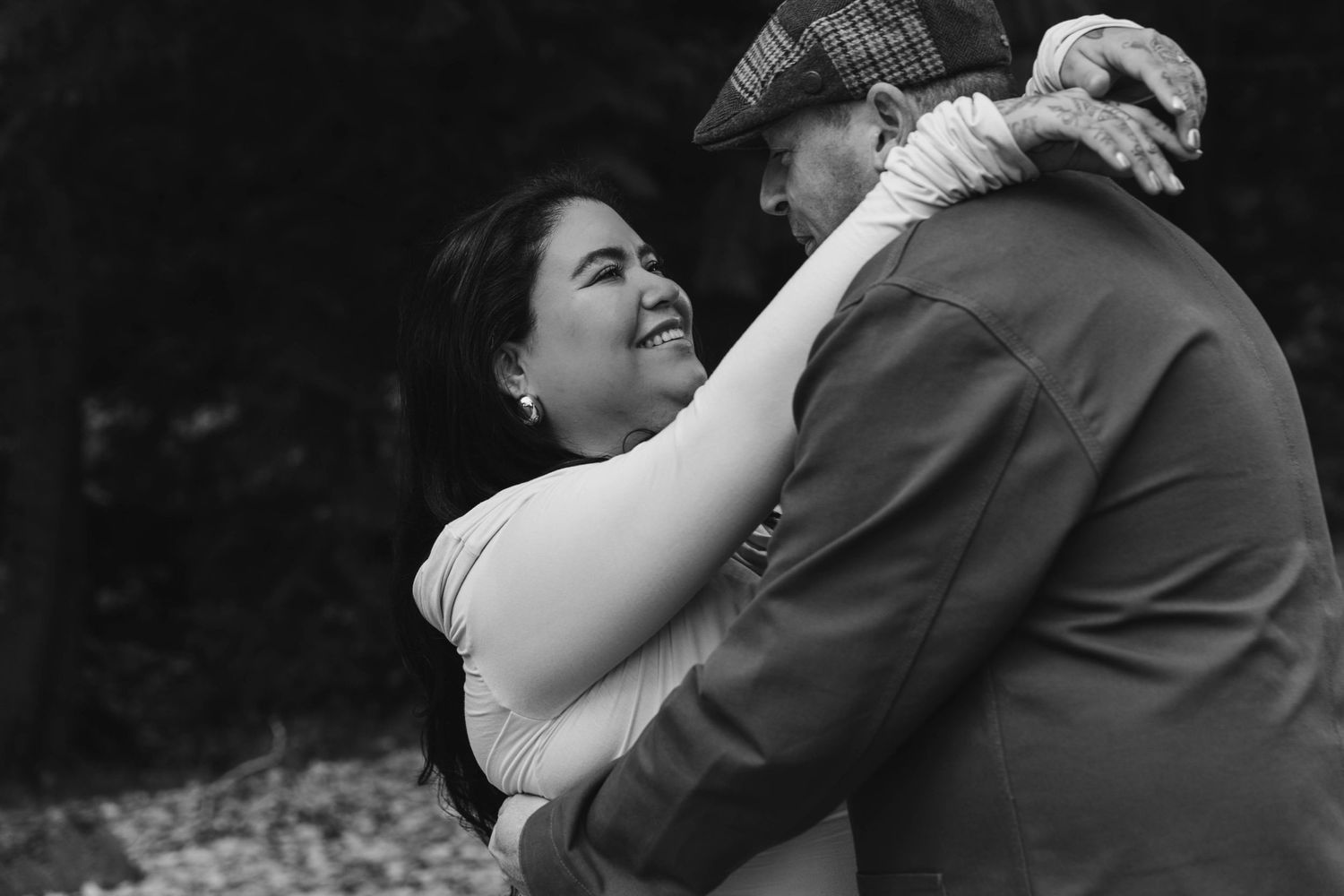 A black and white intimate moment captured during an outdoor photoshoot.