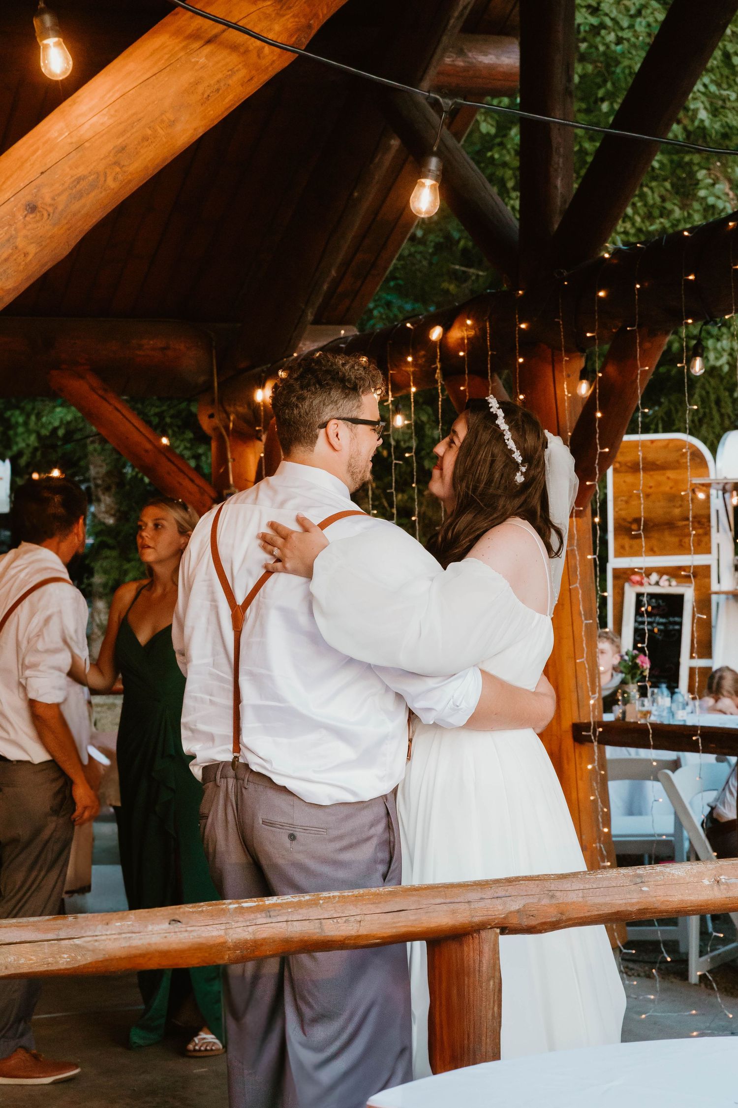 Newlyweds embrace during a romantic dance at their rustic barn reception.