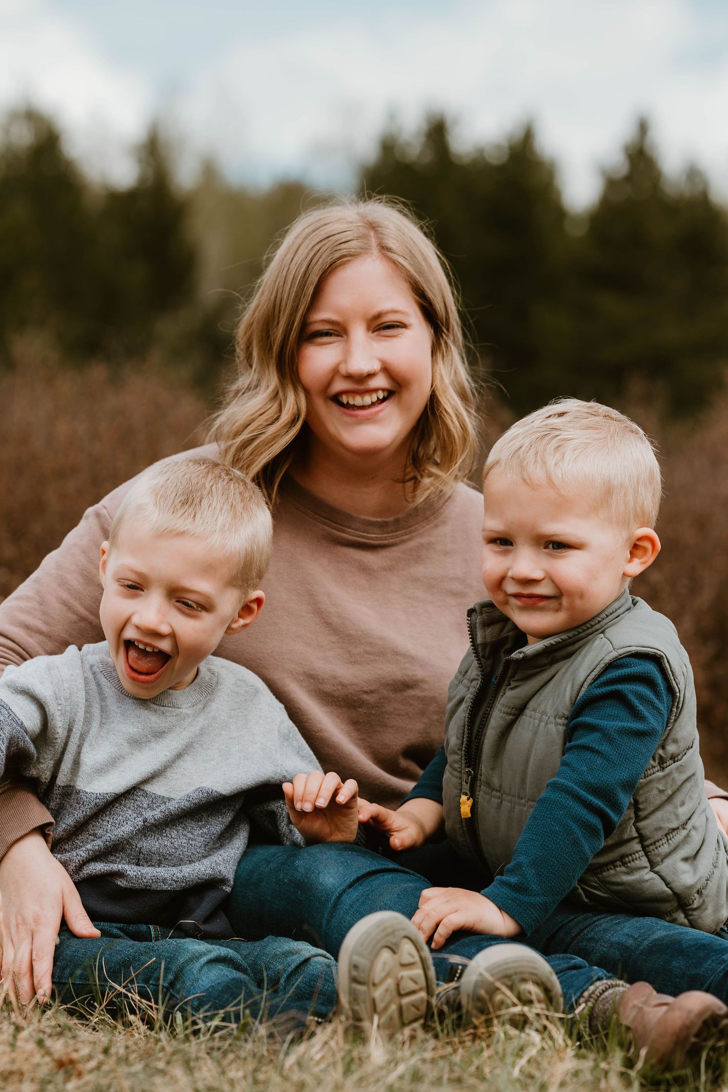 Happy family moment captured outdoors with joyful expressions in a natural setting.