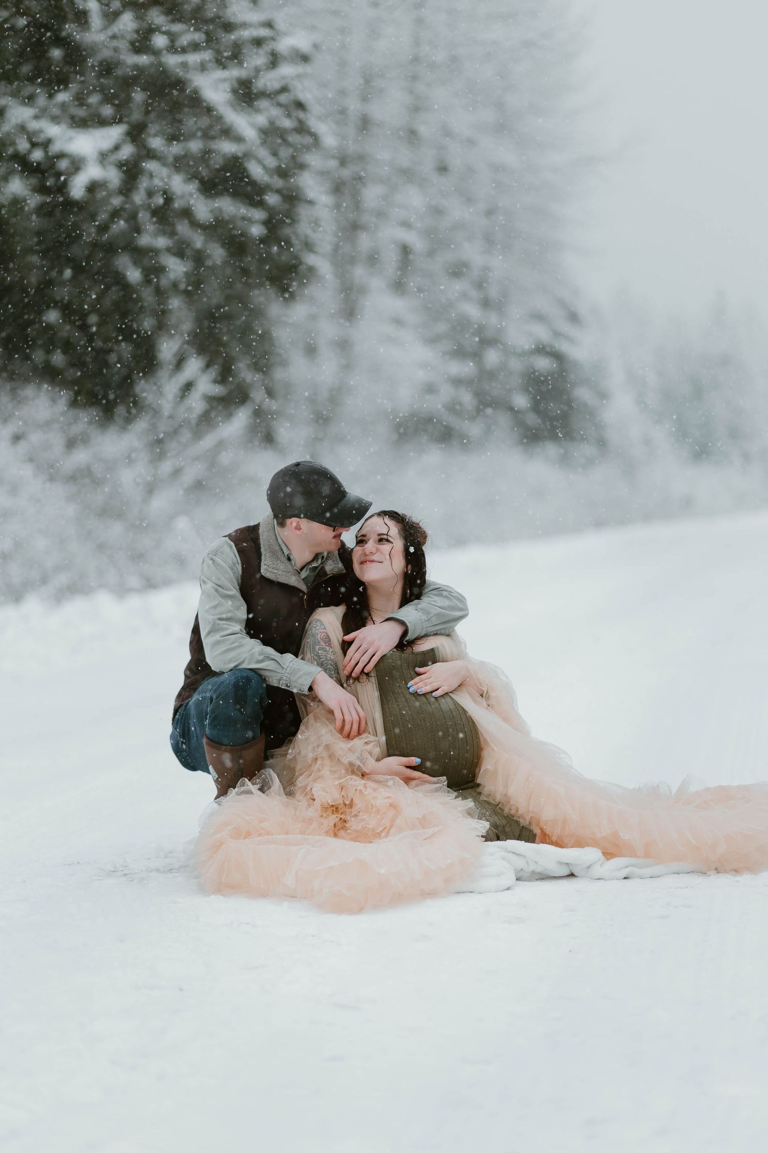A romantic winter moment with a couple in the snow, featuring a flowing pink dress.