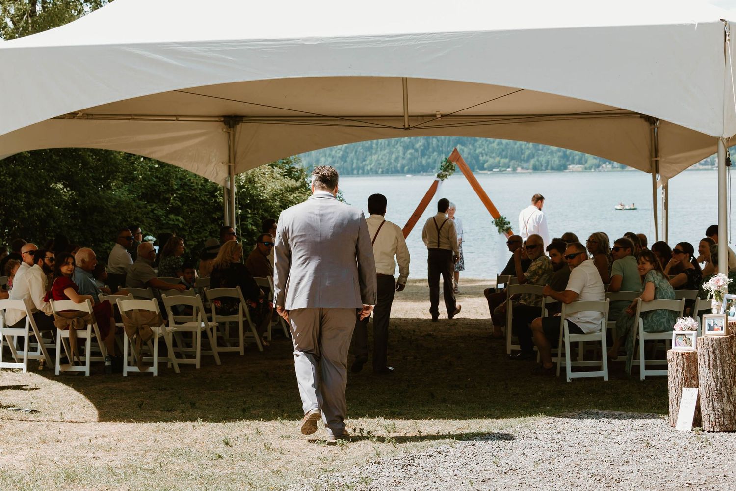 Wedding guests celebrate under a white tent canopy as the newlyweds make their grand exit.