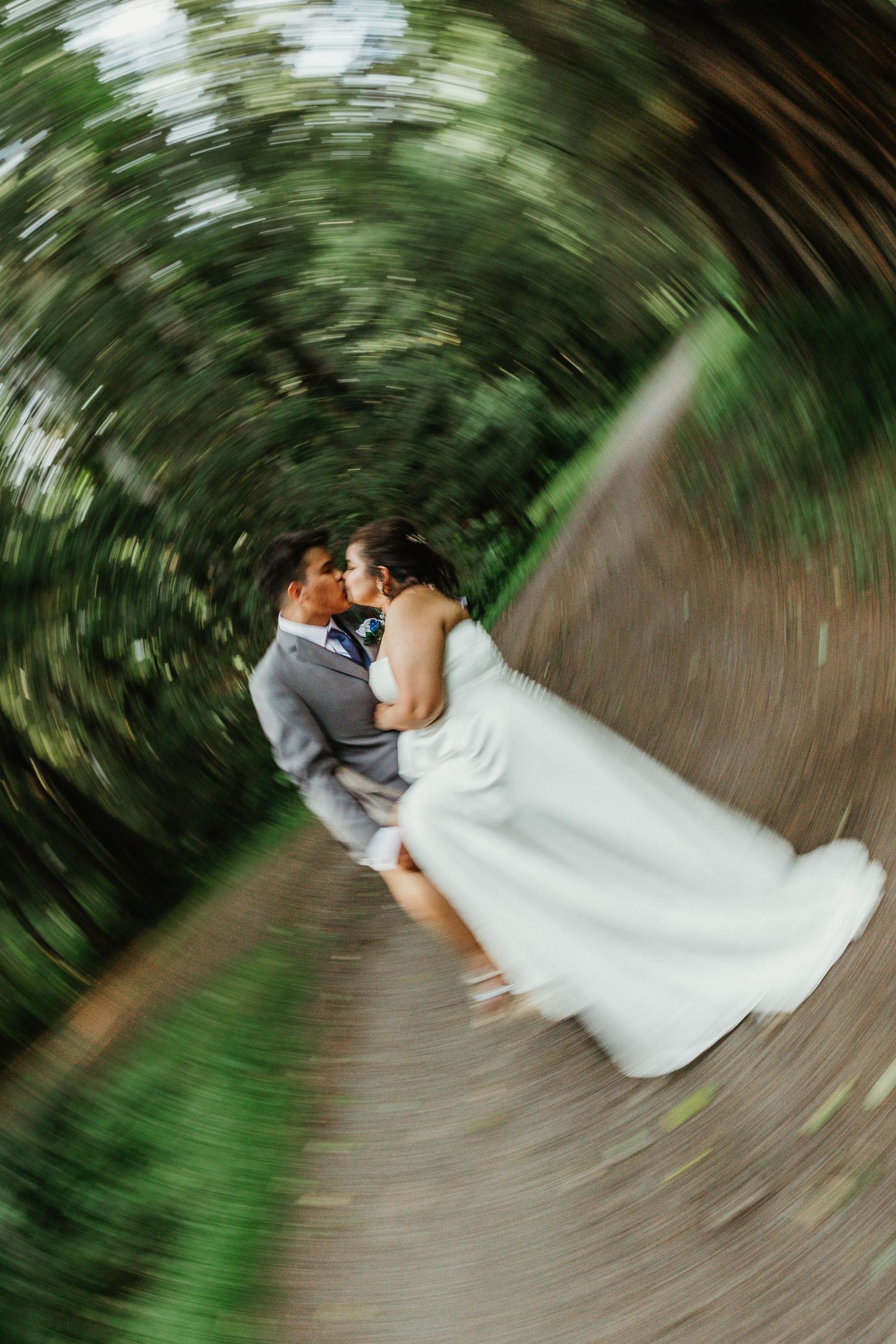 Creative spinning camera effect captures newlyweds in forest setting.
